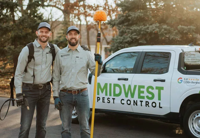 Owners standing next to Midwest Pest Control truck