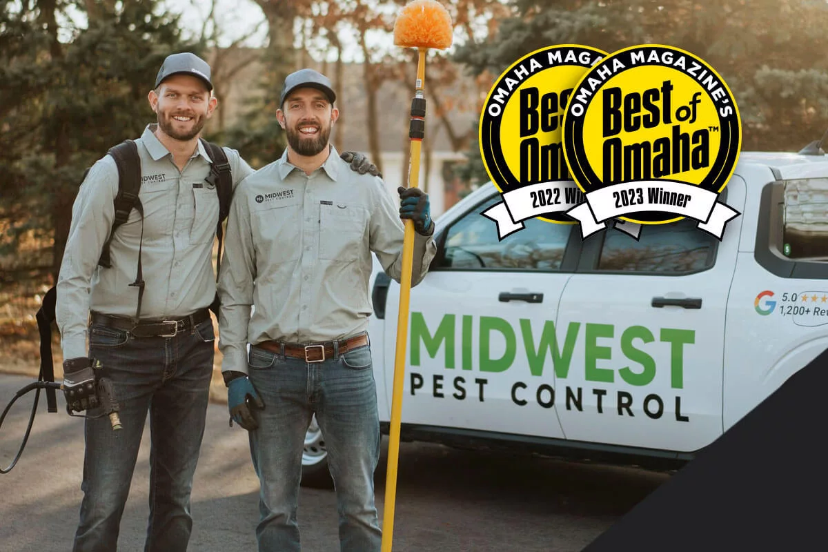Owners standing next to Midwest Pest truck