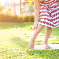 Child in Yard Scratching at Mosquito Bites